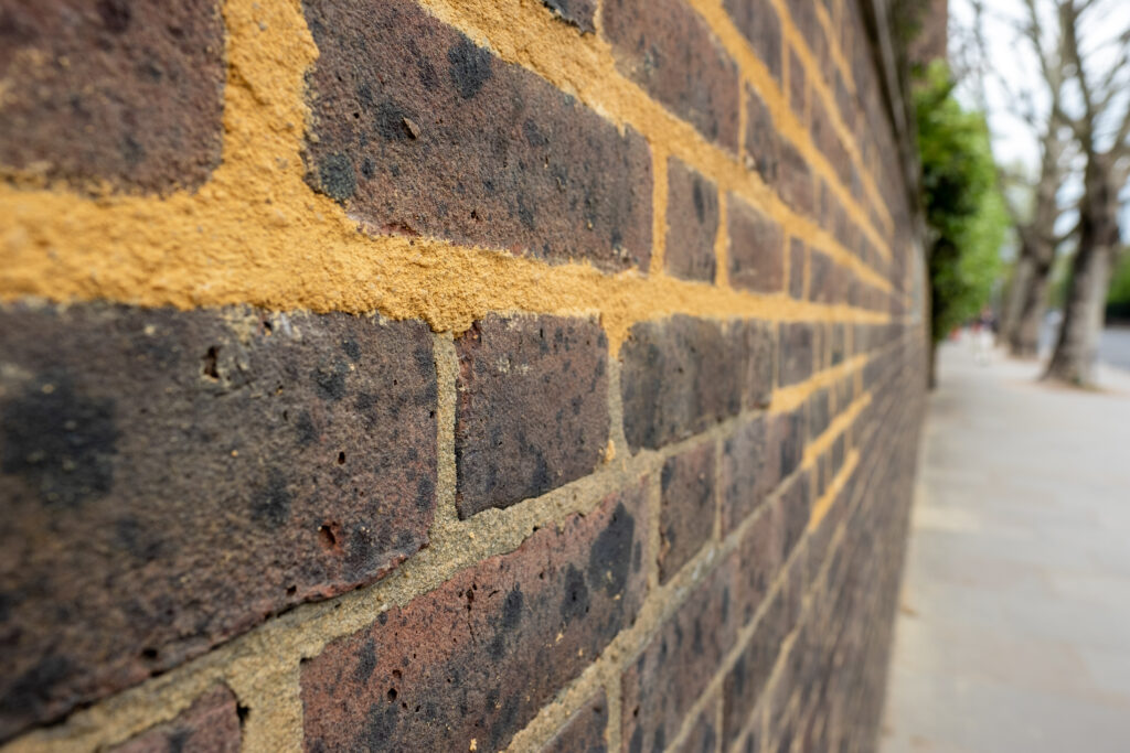 Repointing work on an old brick wall with mortar mix