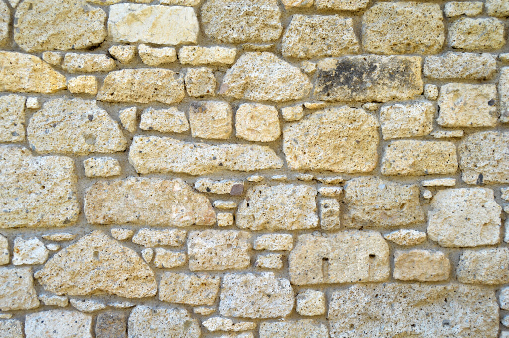 Sturdy yellow and beige cut stone wall, seamless lined up